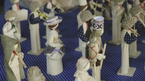 Close-up overhead shot from left of spread corn husk figurines – eco art Stock Footage 313792829