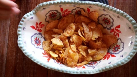 Close-up overhead view grabbing bagged potato chips from a bowl with multiple ha Stock Footage 199581693