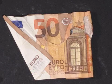 Close-up overhead view of a torn, folded, and damaged 50 euro banknote Stock Photos