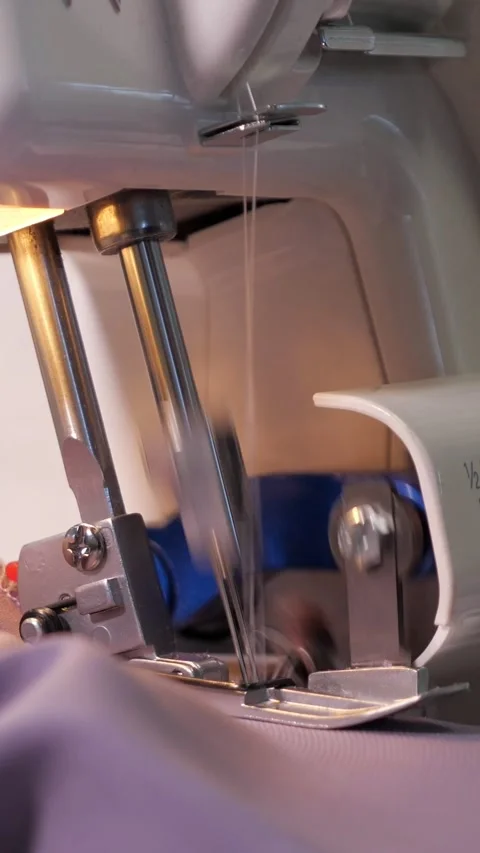 Close up of overlock sewing machine stitching fabric, with multiple threads and Stock Footage 341446577