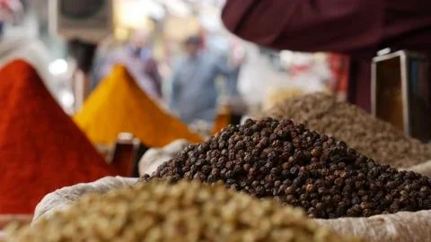 Close up overview across lots of peppercorns and vibrant colourful herb and Stock Footage 201146969