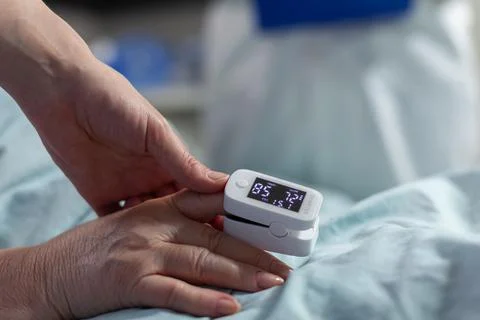Close up of oxymeter attached on sick senior patient Stock Photos