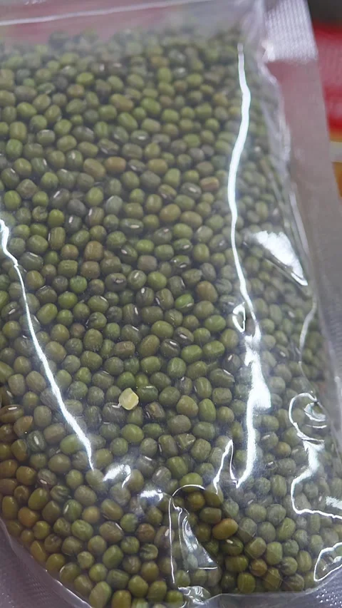 Close-up of packaged dry mung beans held in hand at grocery store Stock Footage 336663302