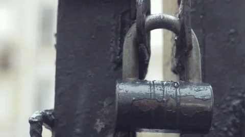 Close up padlock on iron gates under rain Stock Footage 69038082