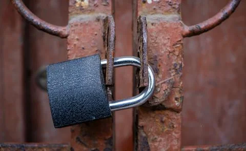 Close Up Of A Padlock Securing An Old Rusty Gate limited access internet Stock Photos