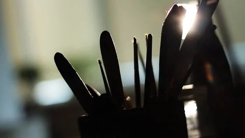 Close up paint brushes in light blows through the darkness artwork oil painting Stock Footage 98261570