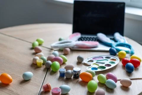 Close-up of painted Easter eggs and laptop on wooden surface Stock-Fotos