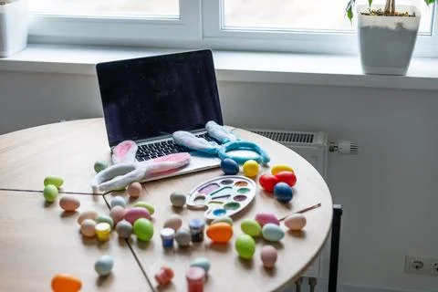 Close-up of painted Easter eggs and laptop on wooden surface Stock Fotos