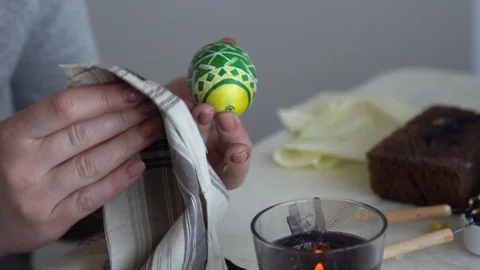 Close-up. painted egg over a candle. remove wax. painting eggs Video stock 127957862