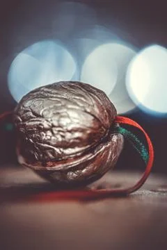 Close-up of a painted silver nut with red and green ribbon on a dark backgrou Stock Photos