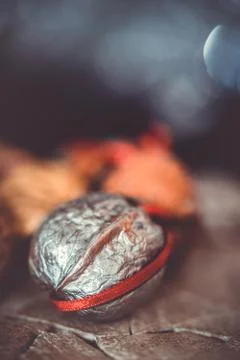 Close-up of a painted silver nut with red and green ribbon on a dark backgrou Stock Photos