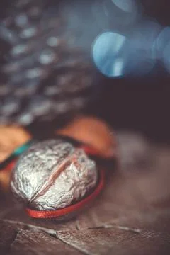Close-up of a painted silver nut with red and green ribbon on a dark backgrou Stock Photos