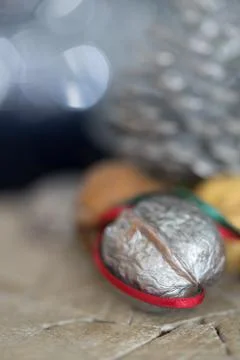 Close-up of a painted silver nut with red and green ribbon on a dark backgrou Stock Photos