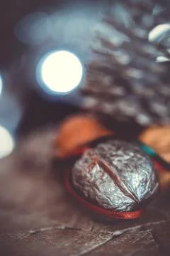 Close-up of a painted silver nut with red and green ribbon on a dark backgrou Stock Photos