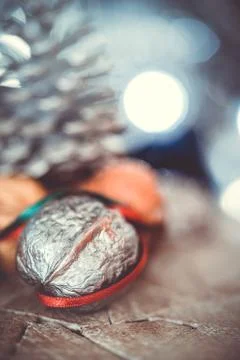 Close-up of a painted silver nut with red and green ribbon on a dark backgrou Stock Photos