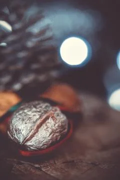 Close-up of a painted silver nut with red and green ribbon on a dark backgrou Stock Photos