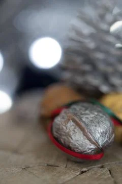 Close-up of a painted silver nut with red and green ribbon on a dark backgrou Stock Photos