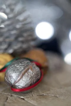Close-up of a painted silver nut with red and green ribbon on a dark backgrou Stock Photos