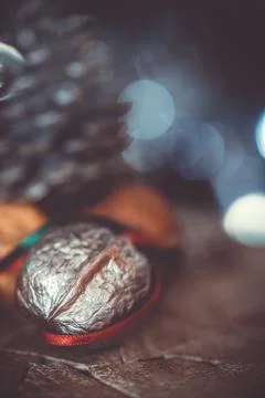 Close-up of a painted silver nut with red and green ribbon on a dark backgrou Stock Photos