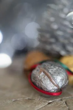 Close-up of a painted silver nut with red and green ribbon on a dark backgrou Stock Photos