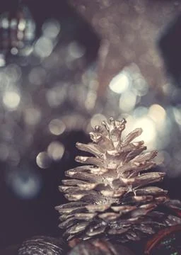 Close-up of a painted silver pine cone on a christmas tree on a dark backgrou Foto stock