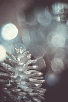 Close-up of a painted silver pine cone on a christmas tree on a dark backgrou Stock Photos