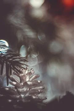 Close-up of a painted silver pine cone on a christmas tree on a dark backgrou Stock Photos