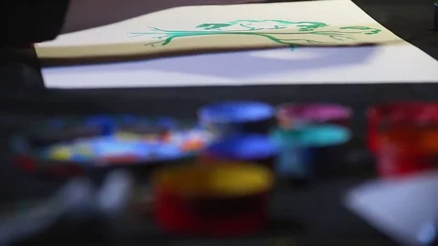 Close up of painter artist hand with brush drawing on white sheet of paper and Stock Footage 84979595