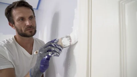 Close up of painter with gloves painting the wall edge by door frame. Stock Footage 129140072