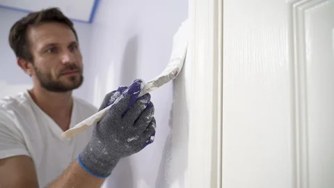 Close up of painter hands with gloves painting the wall edge by door frame. Stock Footage 129140210
