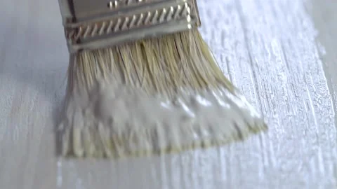 Close-up painter paints floor or table in white using brush, home repair Stock Footage 148119901