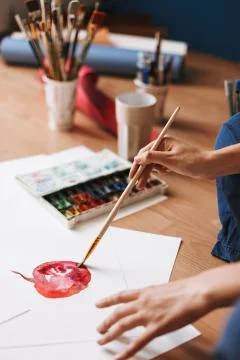 Close up painter sitting on floor drawing by colorful watercolor on paper with Stock Photos
