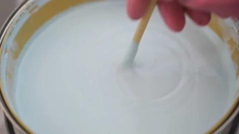 Close-up of a painter stirring white paint. The concept of renovation and Stock Footage 156813639