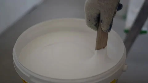 Close-up of a painter stirring white paint. The concept of renovation and Stock Footage 163596596