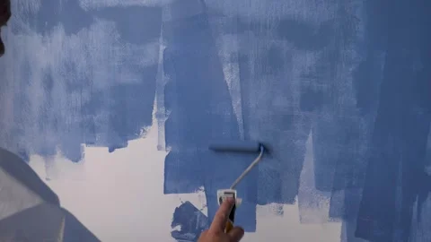 Close Up Of Painter Worker Painting White Wall With Blue Paint Stockbeeldmateriaal 252204669