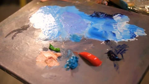 Close-up. Palette with multi-colored paints. The artist mixes color. 4K Slow Mo Stock Footage 106063919