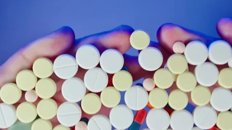 Close-up palms covers a large number of medical pills on the transparent table Stock Footage 261185795