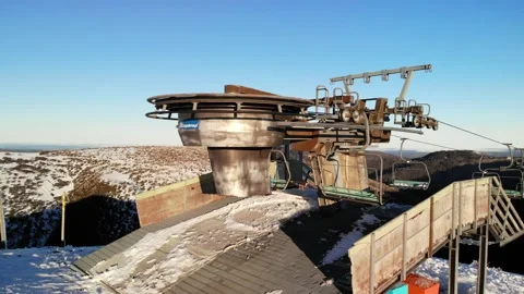 Close Up Pan Across Old Rusted Chairlift on Sunny Winter Day Aerial 4K Stock Footage 137880596