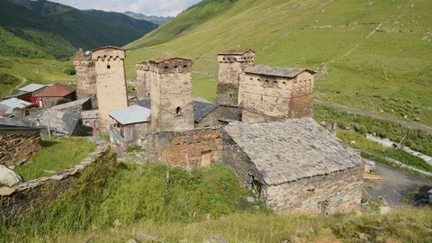 Close pan across of the stone medieval fortified Svaneti tower houses of  Ushgul Stock Footage 104625355