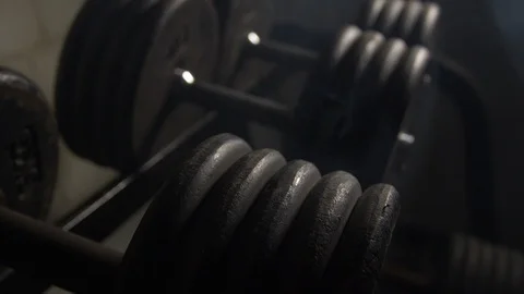 Close Up Pan Along Of Weights Lined Up On Weight Rack In Industrial Gym Old Stock Footage 123063818