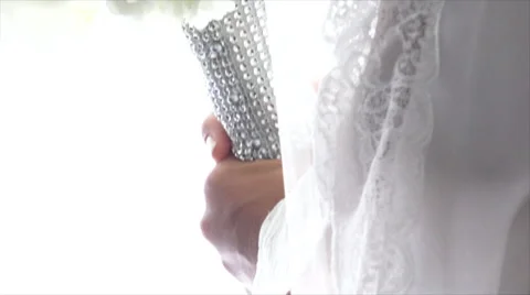 Close up Pan Down of Bride Holding White Flowers Near Windows Stock Footage 43691359