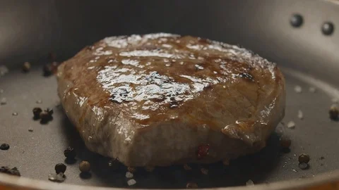Close-up on the pan with grilled beef steak throw pepper and rozmarin Stock Footage 112088154