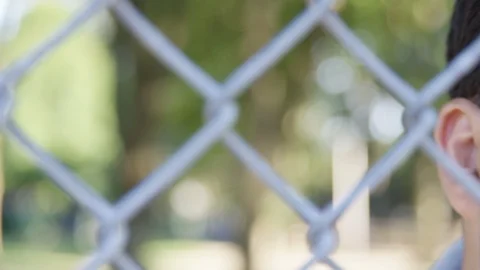 Close Up - Pan to Indian man staring through a fence, defeated and hurt - Slow Stock Footage 125093020