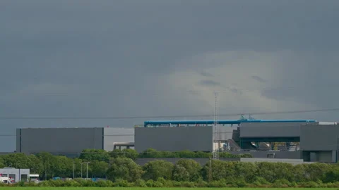 Close Up Pan of Industrial Facility with Smokestack and Rooftop Pipes Emitting Video stock 345842806