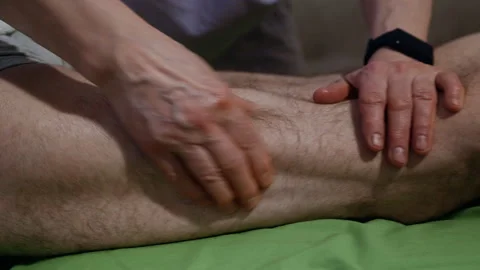 Close-Up Pan of Masseurs Hands Massaging Male Client’s Legs Video stock 311370160