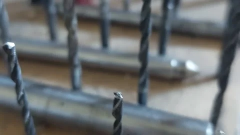 Close-up pan over a row of metal twist drill bits in a stand Vídeos de archivo 336461615