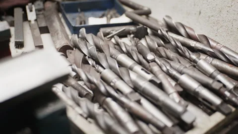 Close-up pan over a tray of heavy-duty industrial drill bits in a workshop Stockbeeldmateriaal 331628959