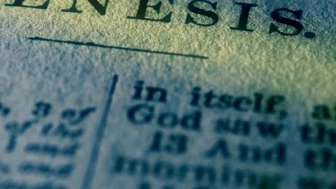 Close up pan on the page of Genesis in a Holy Bible with light effect Stock Footage