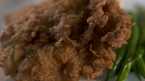 Close up pan right of fried chicken and sides  動画素材 112575471