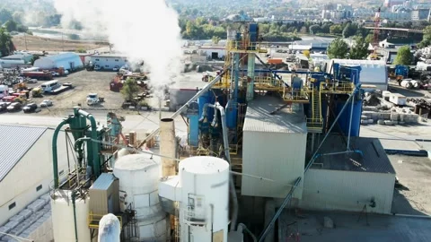 Close pan right shot of large Silos on a Industrial Complex  and Chimney Stock Footage 221765544
